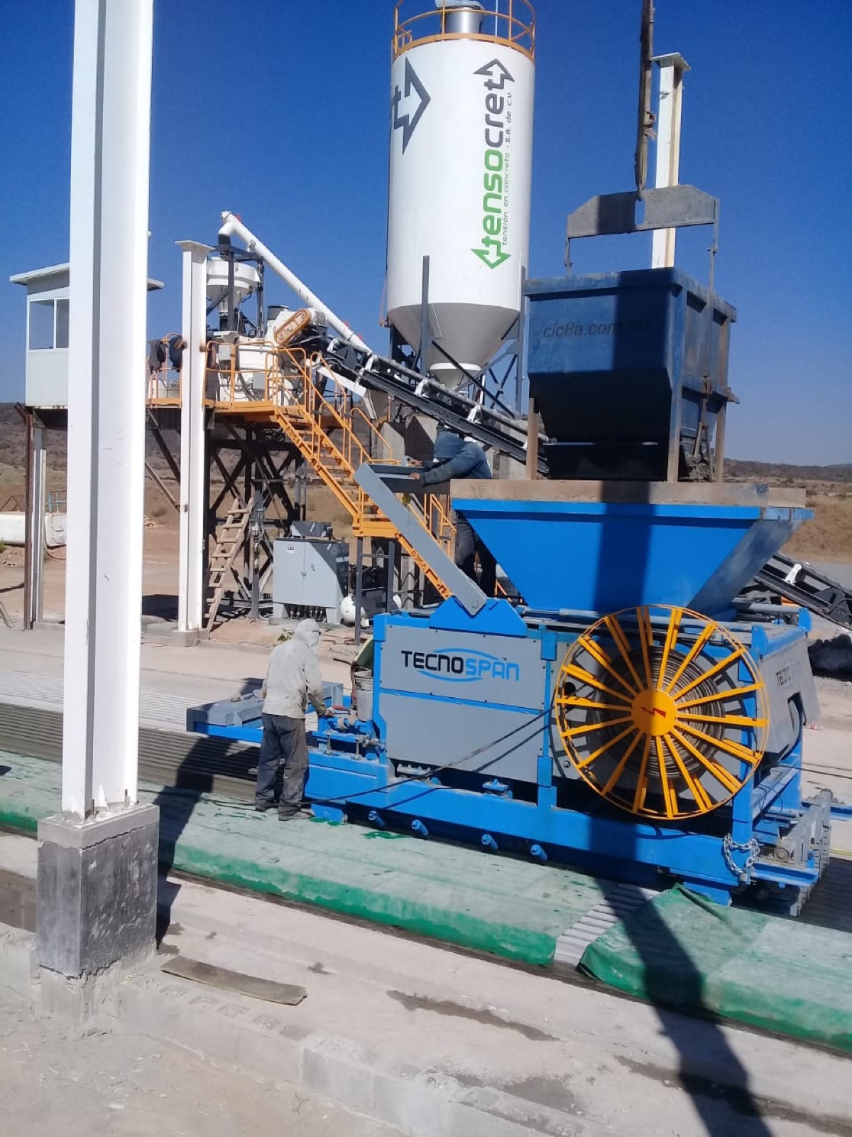 Planta de producción de Tensocret: silo de cemento con logo Tensocret y extrusora TecnoSpan sobre cama de colado